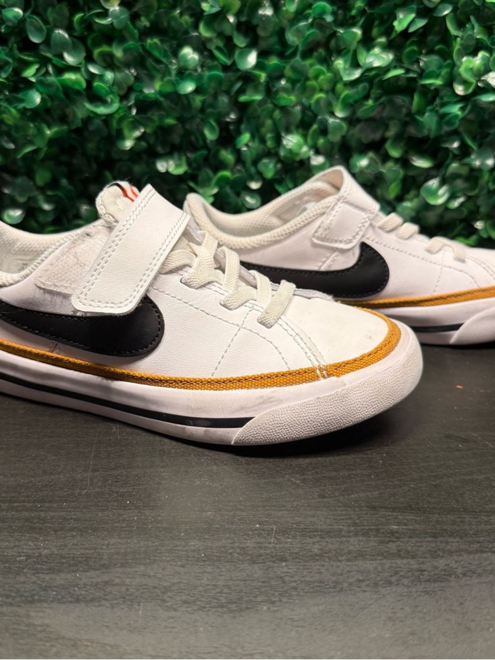 Nike Kids White Sneakers with Black Swoosh and Gold Accent